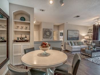 Furnished model dining and living area with built in shelving nooks